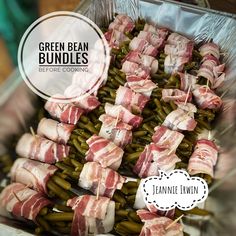 green bean bundles are wrapped in bacon on top of asparagus and other vegetables