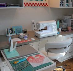 a sewing machine sitting on top of a table next to a white chair and desk