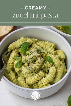 two white bowls filled with pasta and pesto