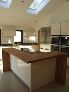 a large kitchen with an island in the middle and skylights on the ceiling above it