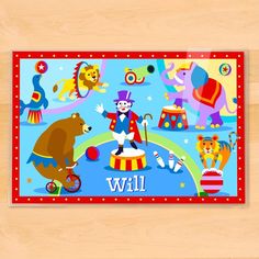 a wooden table topped with an animal themed placemat and a circus theme on it