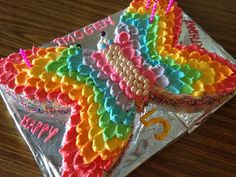 a birthday cake decorated like a butterfly on a table