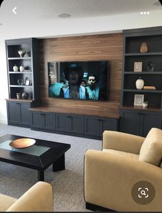 a living room filled with furniture and a flat screen tv mounted to the side of a wall