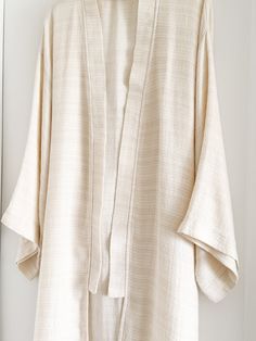 Elevate your lounge wear style with the Ivory Smooth Textured Turkish Cotton Kimono, woven with a beautifully intricate pattern that feels incredibly soft against the skin. Crafted from 100% Turkish Cotton, it ensures both comfort and style for your moments of relaxation at home. Available in one size. Color: Ivory. Material: 100% Cotton. Made in Turkey. Unisex one size. Machine wash delicate. Tumble Dry low. Elegant Long Sleeve Relaxed Fit Kimono, White Relaxed Fit Kimono For Loungewear, White Spring Kimono For Relaxation, Elegant Cotton Kimono, Cream Long Sleeve Kimono For Loungewear, Beige Relaxed Fit Kimono For Loungewear, Elegant Beige Kimono For Loungewear, Relaxed Fit Beige Kimono For Loungewear, Beige Long Sleeve Kimono For Loungewear