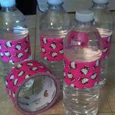 three water bottles with hello kitty designs on them, one is empty and the other two are full