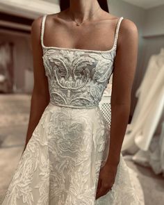 a woman in a wedding dress is standing