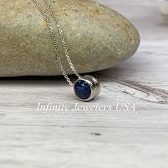 "The pendant pictured is lab created blue sapphire #5871 -Approximate total carat weight: approx. .80ctw diamond equivalent -Center Stone Size: 6mm - approx. .80ct diamond equivalent -Center Stone Shape: round -Gem Type: lab created sapphire -Stone Clarity: VS2 -Stone Color: Blue -Moh's Scale: 9 hardness -Metal Type and Purity: 14k white gold -Setting: bezel set floating necklace -Chain: 18\" delicate 14k gold chain / heavier option with lobster claw available (use dropdown to select) -Country o Blue Round Pendant Jewelry For Anniversary, Anniversary Necklace With Lab-created Sapphire Birthstone, Blue Sapphire Birthstone Necklace For Anniversary, Sapphire Birthstone Necklace In Sterling Silver, Sapphire Jewelry With Tension Setting, Round Lab-created Sapphire Birthstone Jewelry, Lab-created Sapphire Round Necklace For Gift, Lab-created Sapphire Birthstone Jewelry, Sapphire Round Pendant Jewelry With Polished Finish