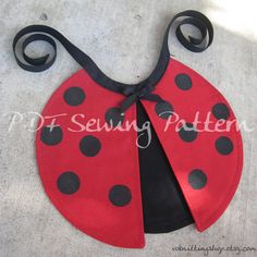 a little ladybug bib with black dots on it