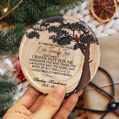 a person holding a wooden plaque with a tree and poem on it, surrounded by christmas decorations