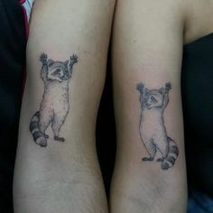 two raccoon tattoos on both legs with one holding the other's hand