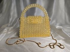 Handmade Crystal Yellow Beaded Bag with Golden-Toned Hardware This elegant handbag, crafted from crystal yellow beads, features golden-toned hardware and a 47-inch removable chain. The magnetic closure adds convenience and ease of use. Our bags are 100% handmade. Each bag is unique and crafted with love for our customers. It takes 3-5 days to create one bag. A perfect gift for women, friend, family member or loved one. Ideal for any celebration, event, wedding or birthday party. This unique and Yellow Beaded Party Bag, Elegant Yellow Beaded Bag, Gold Bags With Gold Beads For Gifts, Luxury Gold Beaded Evening Bag, Crystal Yellow, Elegant Handbag, Beaded Bag, One Bag, Beaded Bags