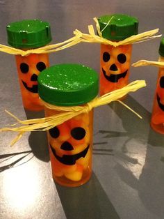 four jars with candy in the shape of jack - o'- lantern faces