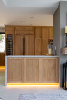 a kitchen with wooden cabinets and lights on the counter top, along with a rug in front of it