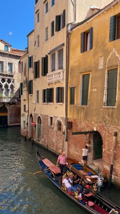 a gondola on the side of a canal with buildings in the back ground