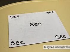 a sign that says see and see on the side of a table with black letters