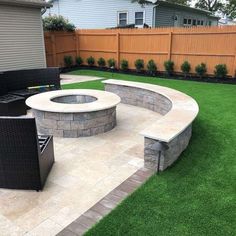 a backyard with grass, fire pit and patio furniture