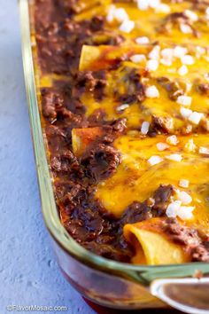 an enchilada casserole with meat and cheese in a glass dish