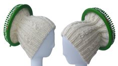 two white knitted hats with green trims