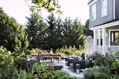 an outdoor patio area with furniture and trees in the background, surrounded by greenery