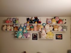 there are many stuffed animals on the shelves in this room, and one is hanging from the wall