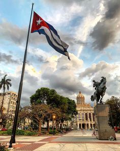 there is a flag flying in front of a statue