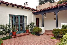 the front entrance of a house with potted plants