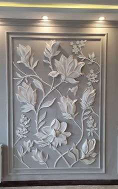 a white wall with flowers and leaves on the paneled in area that is painted gray