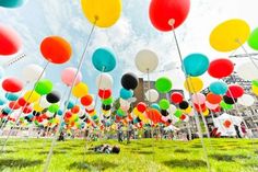 many colorful balloons are floating in the air