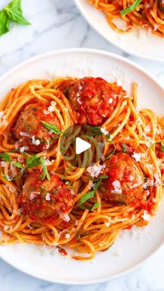 two plates of spaghetti with meatballs and tomato sauce on the top one plate is white