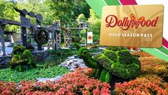 a sign that says dollywood gold season pass in front of some flowers and trees