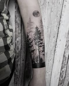 a person with a forest tattoo on their arm