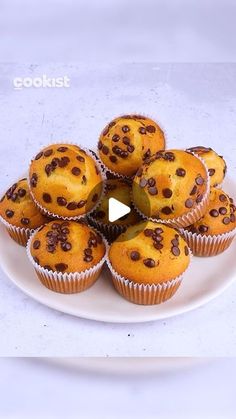 a white plate topped with muffins covered in chocolate chips