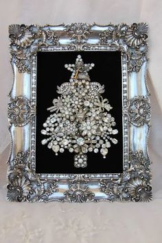 an ornate silver frame with a christmas tree in the center and pearls on it's sides