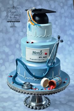 a blue cake with a graduation cap on top and stethoscope attached to it