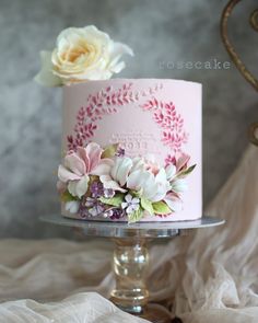 there is a pink cake with flowers on it