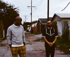 two men standing in the street next to each other