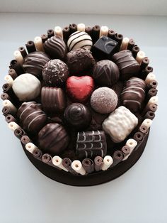 a cake with chocolates and candies arranged in the shape of a heart on top