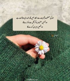 someone holding a flower in their hand with an arabic text above it that reads,