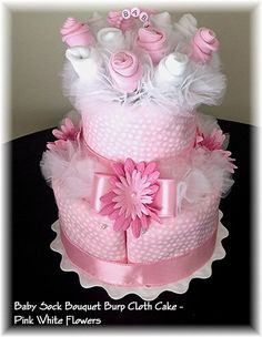 a baby pink and white diaper cake with flowers