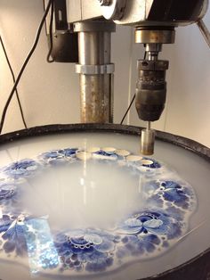 a machine that is making something blue and white with flowers on it's side