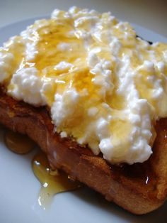 a piece of bread topped with whipped cream and caramel sauce on a white plate