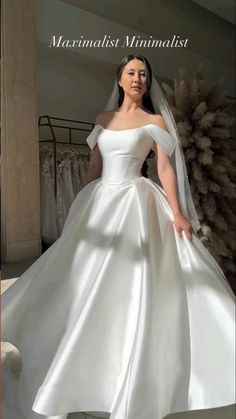 a woman in a white wedding dress posing for the camera