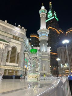 a bottle of water sitting on top of a table in front of a tall building