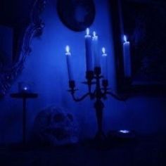 a blue room with candles lit up in the dark