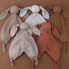 six baby bunnies laid out on a brown background, all in different colors and sizes