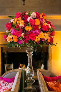 a vase filled with colorful flowers sitting on top of a table next to a couch