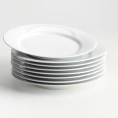 a stack of white plates stacked on top of each other in front of a white background