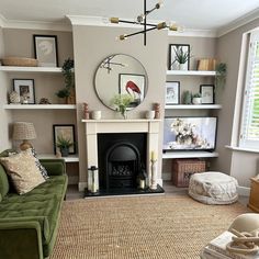 a living room filled with furniture and a fire place in front of a mirror on the wall