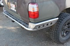 the rear end of a gray truck parked in a parking lot