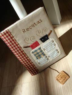 a cross stitch book sitting on top of a wooden floor